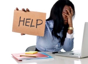 woman-holding-help-sign-in-front-of-laptop-image-from-shutterstock