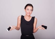 woman-holding-two-cellphones-shrugging-image-from-shutterstock