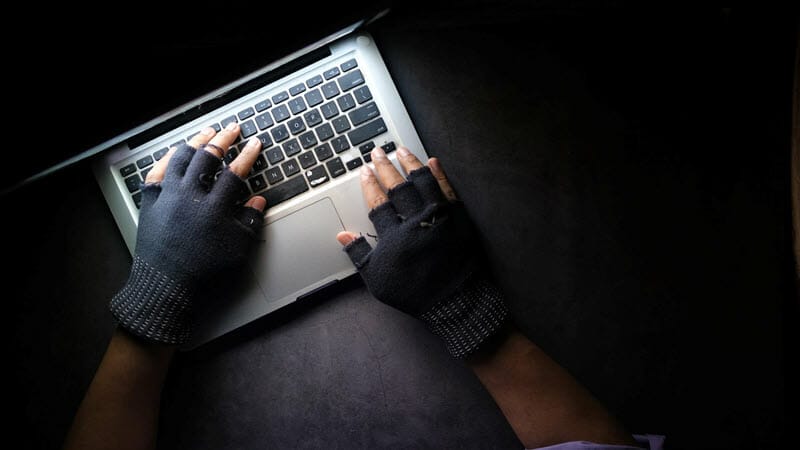 A hacker working on a laptop in the dark - image licensed from unsplash.com